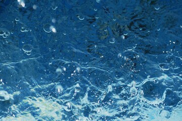 Clear blue water splash with bubbles summer background