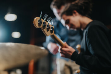 Musicians rehearsing in a studio with focus on guitar and creativity