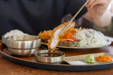 He's dipping pork cutlet in the sauce 돈까스를 소스에 찍고 있는 모습