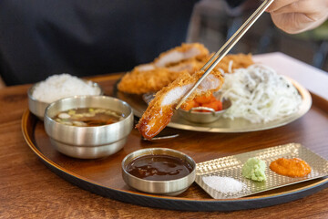 He's dipping pork cutlet in the sauce 돈까스를 소스에 찍고 있는 모습