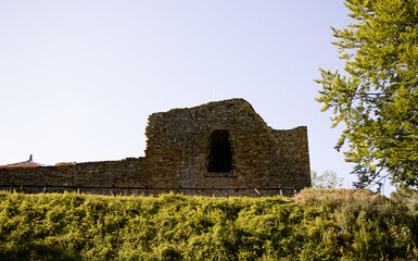 A wide shot of the substantial stone remnants of an ancient castle, rising majestically against a...