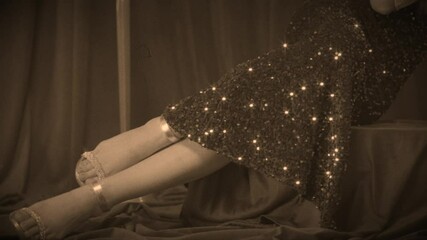 body part, legs feet in silver heeled sandals sparkly sequin dress Retro lady sexy woman fashion model posing, old roar style 20s 30s years. Glamour girl white fox faux fur boa cape. film sepia color