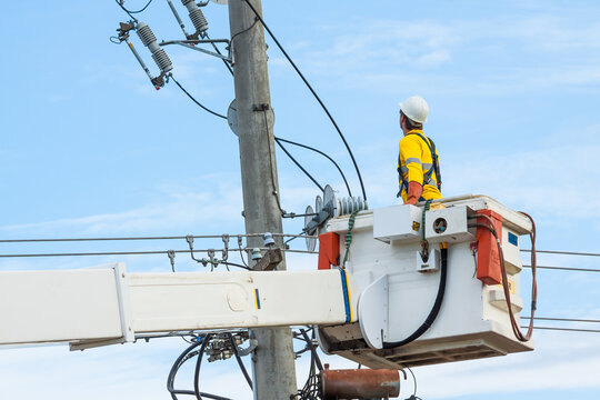 A man working on power lines from a cherry picker