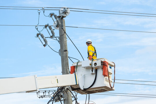 A man working on power lines from a cherry picker