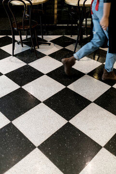 Waitress walking on a Chequerboard tiled Floor
