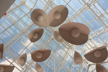 The installation features an artistic ceiling with abstract shapes and a vibrant blue sky