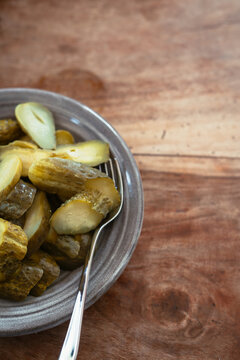 dill pickles in an earthenware bowl with fork