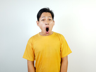 Surprised Asian Man Wearing a Yellow Shirt Against a Bright Background