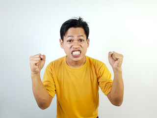 Angry Man in Yellow Shirt Showing Intense Expression with Fists Raised