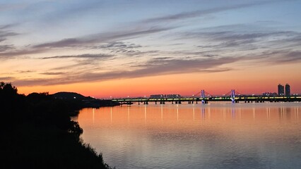 양화대교를 중심으로 서울 한강에 비친 붉은 노을과 도시의 불빛