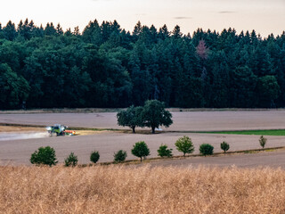 Ein Mähdrescher bei der Erntearbeit auf einem Weizenfeld