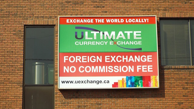 Ottawa, ON, Canada-July 6,2025: A sign for "Ultimate Currency Exchange" which advertises "FOREIGN EXCHANGE NO COMMISSION FEE" on Carling Avenue.