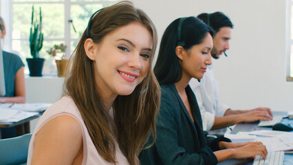 Businesswoman Working In Multi-Cultural Team Wearing Headsets In Customer Service Department