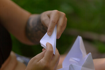 A person is holding a piece of paper securely in their hands, ensuring it does not slip away or...
