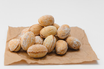 Delicious nut shaped cookies with boiled condensed milk on white background