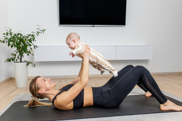 Mother doing home workout while holding baby