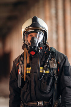 Fototapeta Protective air mask is on the face. Firefighter in professional equipment is indoors in abandoned building