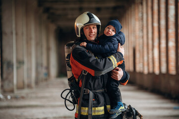 Firefighter is with baby boy indoors