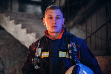 Firefighter in professional equipment is indoors in abandoned building
