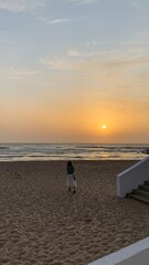 A serene sunset stroll captures a pensive woman of Asian descent, evoking World Ocean Day's...
