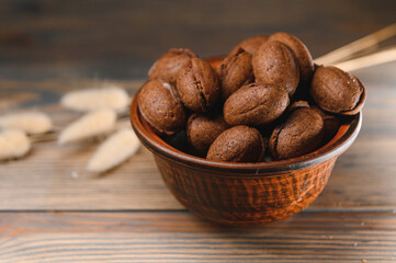 Delicious nut shaped cookies with boiled condensed milk on a wooden background