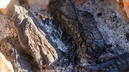Close-up of charcoal among the ashes. Unburned wood on a fire pit