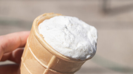 White vanilla ice cream in a waffle cup. Vanilla ice cream in hand