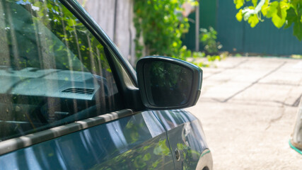 Side-view mirror of a car. The car doors are blue
