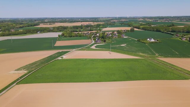 moves seneffe town green fields power lines distant windmills natural agricultural landscape forward aerial drone view belgium lush expansive 