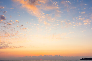 blue sky with orange clouds. nature background at sunrise. sun on the horizon of sea