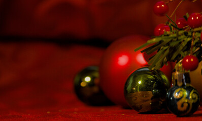 Festive red and green Christmas ornaments with vibrant berries on a textured red background, ideal...