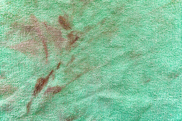 Dirty old unclean green microfiber cloth with grease stains and cat hair. Grunge and rough surface...