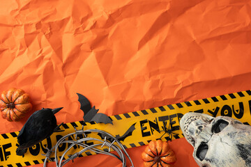 Spooky Halloween arrangement featuring a skull, pumpkins, black bird, and caution tape on a vibrant...