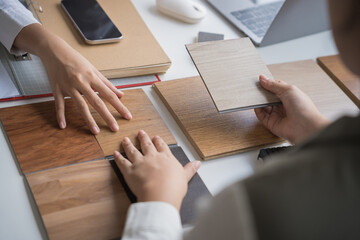 Interior designer presenting eco friendly wooden material samples for sustainable home decor