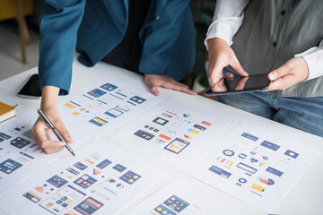 Developer team brainstorming user interface and experience designs for mobile application ux ui graphic prototype.