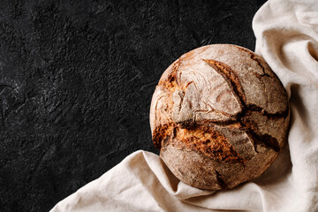 Round sourdough bread on black background