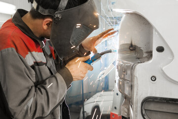 Male in face mask welds with carbon dioxide welding
