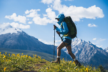 Backpacking woman hiking on grassland mountains