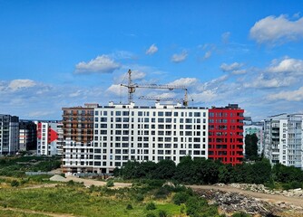 Aerial view of city residential area with high apartment buildings under construction. modern apartment buildings on the sunny day with a blue sky. modern urban apartment apartment building