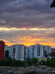 Silhouette of a modern multi-storey building at sunset, colorful sky with clouds, metropolis. Silhouette of the city. View from above