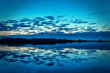 Piscatory settlement, fishing village on the shore of a quiet lagoon. Dawn, clouds, and vague...