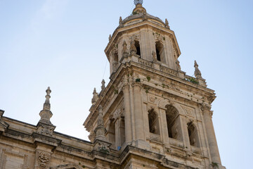 Exploring the historic tower of Santa Iglesia Catedral in Jaen, Andalucia, showcasing intricate detail against a clear sky