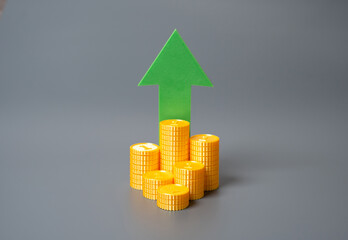 Stack of coins and green arrow pointing up. Financial growth, income increase, or investment...