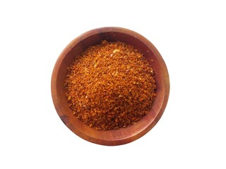 Sprinkle of chopped hot red chili powder or paprika. Pile of crushed dried red chili or paprika. Red chili in a wooden bowl on a white background.