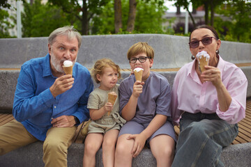 Timeless taste. Grandparents and children eating ice cream together outdoors. Concept of family...