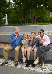 Timeless taste. Grandparents and children enjoying ice cream together in a park setting. Concept of...