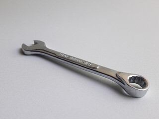 A ring spanner, also known as a combination wrench, isolated on a white background.
