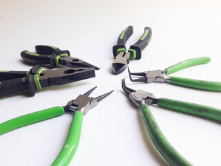 Several types of pliers isolated on a white background, commonly used for work purposes.
