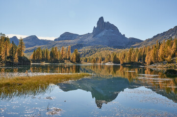 autumn in the mountains with a lake and a mountain in the background in the dolomites