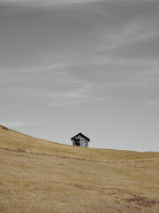 abandoned house in rural landscape with grey sky and clouds